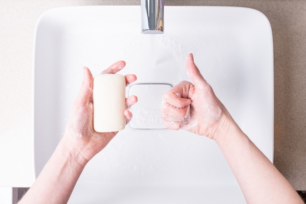 Se laver les mains avec du savon dans la salle de bain