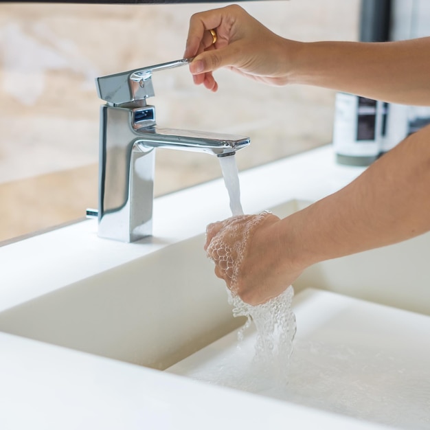 Se laver les mains avec du savon liquide et de l'eau du robinet Concept antiseptique d'hygiène personnelle et de soins de santé