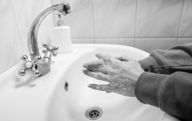 Se laver les mains en se frottant avec un homme au savon pour la prévention des coronavirus photo en noir et blanc