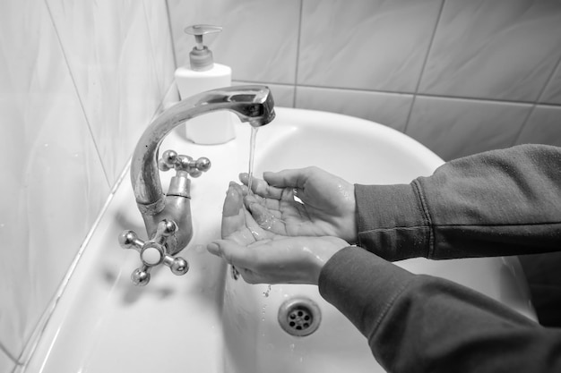 Se laver les mains en se frottant avec un homme au savon pour la prévention des coronavirus photo en noir et blanc