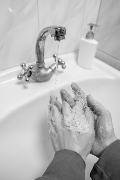 Se laver les mains en se frottant avec un homme au savon pour la prévention des coronavirus photo en noir et blanc