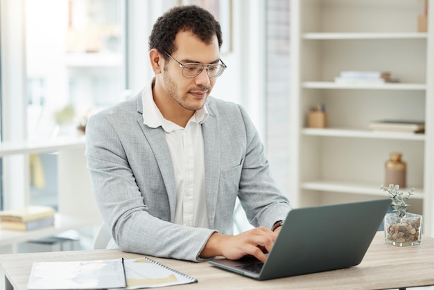 Se mettre au courant de ses plans. Photo d'un jeune homme d'affaires travaillant sur un ordinateur portable dans un bureau.