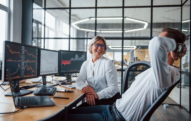 Se parler. Deux agents de change en tenue de soirée font une pause au bureau.