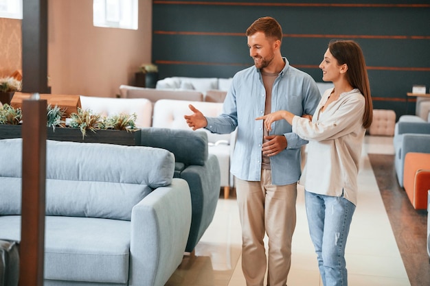 Se promener Couple choisissant le canapé et le lit dans le magasin