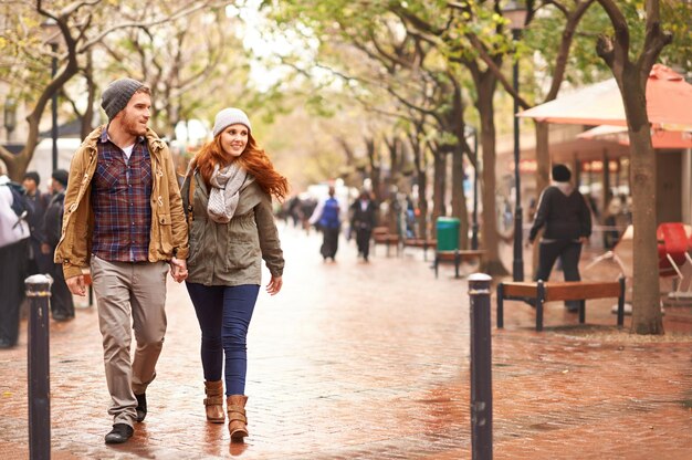 Se promener du côté de l'hiver Photo d'un jeune couple heureux marchant ensemble dans une zone urbaine