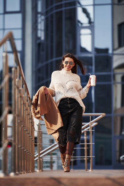 Se promener. Jeune belle fille dans des vêtements chauds dans la ville à son heure du week-end