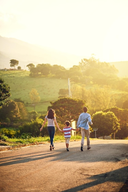 Se promener le long d'une journée tranquille Vue arrière d'une famille se promenant dans la campagne