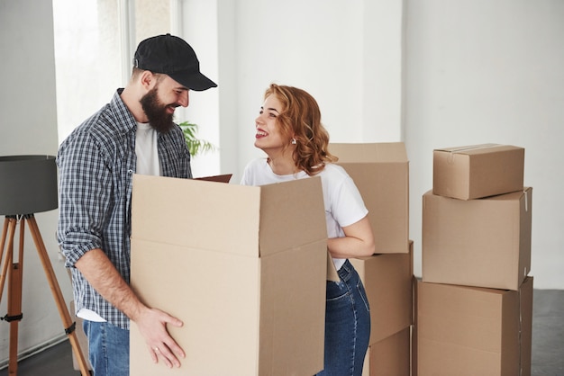 Se regarder. Heureux couple ensemble dans leur nouvelle maison. Conception du déménagement