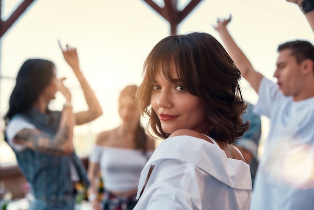 Se sentir belle jolie et jeune femme en chemise blanche sourit et regarde la caméra