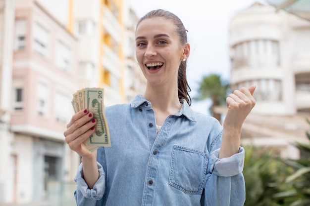 Photo se sentir choqué et célébrer le concept de billets en dollars de succès