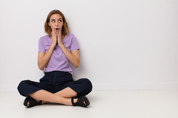 se sentir choqué et effrayé, terrifié avec la bouche ouverte et les mains sur les joues