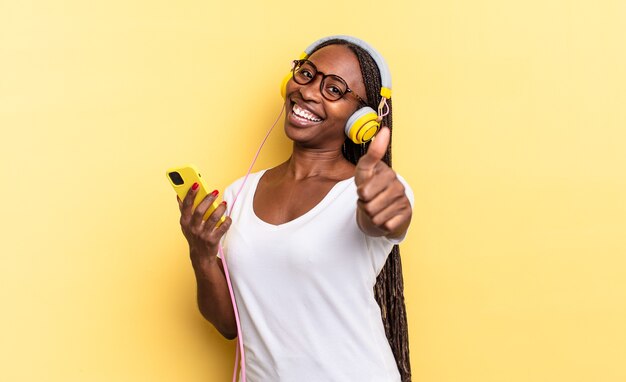 Se sentir fier, insouciant, confiant et heureux, sourire positivement avec le pouce levé et écouter de la musique