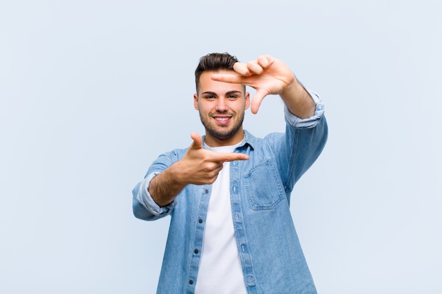 se sentir heureux, amical et positif, souriant et faire un portrait ou un cadre photo avec les mains