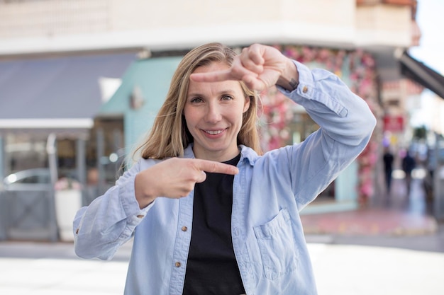 Se sentir heureux, amical et positif, souriant et faire un portrait ou un cadre photo avec les mains