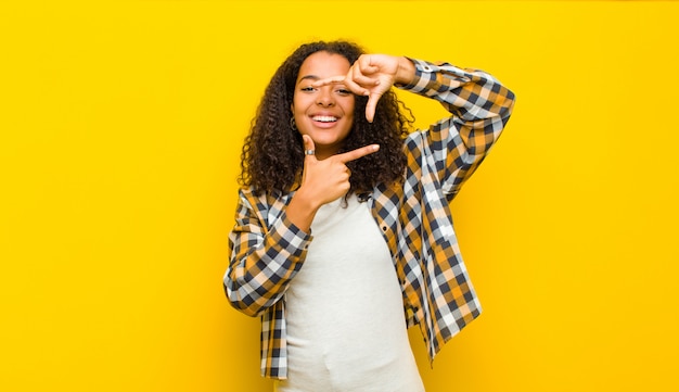 se sentir heureux, amical et positif, souriant et faire un portrait ou un cadre photo avec les mains