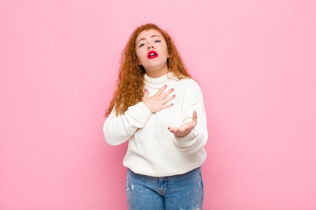 se sentir heureux et amoureux, souriant avec une main à côté du cœur et l'autre tendue vers l'avant