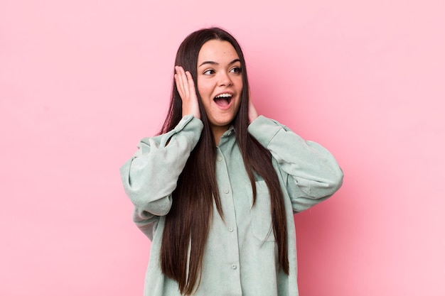 Se sentir heureux, excité et surpris en regardant sur le côté avec les deux mains sur le visage