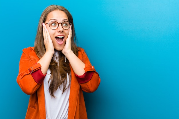 se sentir heureux, excité et surpris, regardant de côté avec les deux mains sur le visage