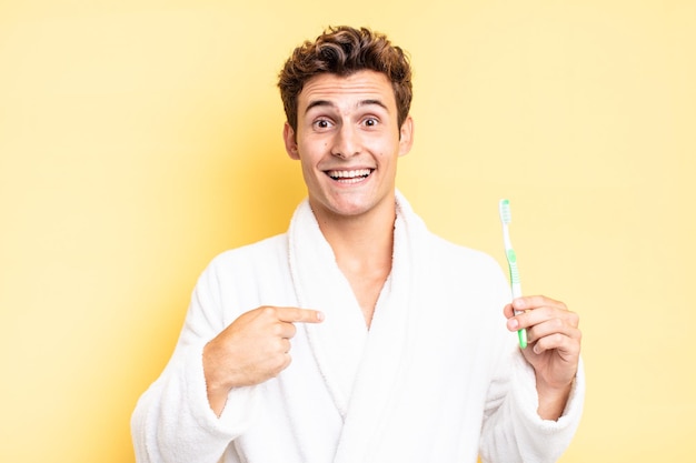 Se sentir heureux, surpris et fier, se montrant lui-même avec un regard excité et étonné. concept de brosse à dents