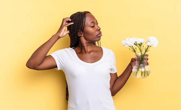 Se sentir perplexe et confus, se gratter la tête et regarder de côté. concept de fleurs décoratives