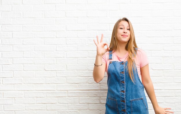 se sentir réussi et satisfait, souriant avec la bouche grande ouverte, faisant signe avec la main