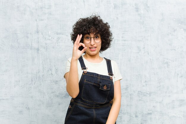 se sentir réussi et satisfait, souriant avec la bouche grande ouverte, faisant signe avec la main