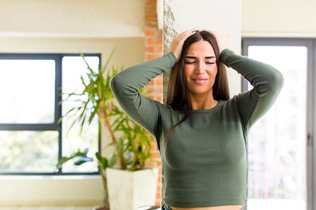 Se sentir stressé et anxieux déprimé et frustré avec un mal de tête en levant les deux mains vers la tête