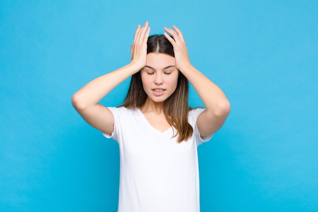 se sentir stressé et anxieux, déprimé et frustré par un mal de tête, levant les deux mains vers la tête