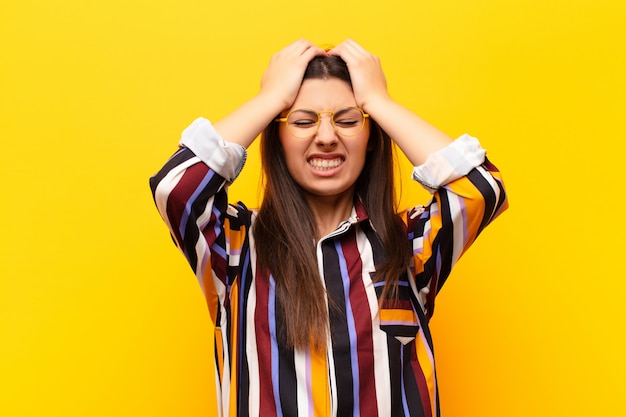 se sentir stressé et anxieux, déprimé et frustré par un mal de tête, levant les deux mains vers la tête