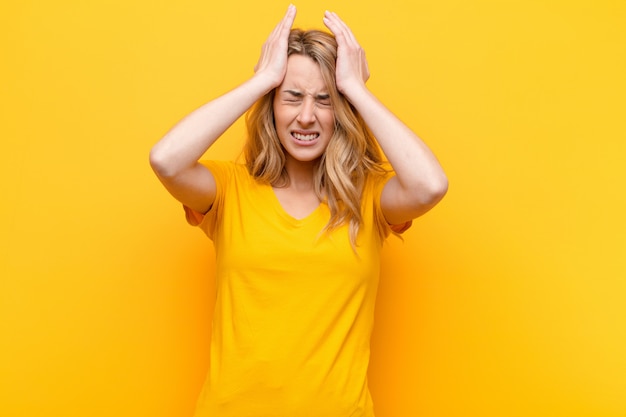 se sentir stressé et anxieux, déprimé et frustré par un mal de tête, lever les deux mains vers la tête