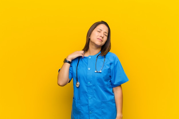 Se sentir stressé, anxieux, fatigué et frustré, tirer le cou de la chemise, semblant frustré par un problème isolé contre un mur jaune