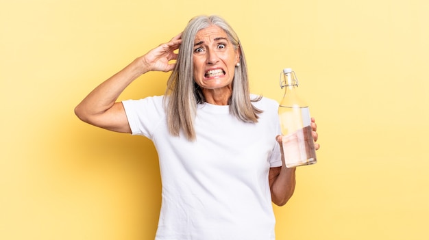 Se sentir stressé, inquiet, anxieux ou effrayé, les mains sur la tête, paniquer par erreur et tenir une bouteille d'eau