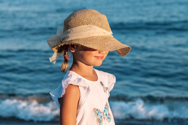 Sea Relax vacances d'été vacances enfant au chapeau couvrant le visage du soleil enfant sur fond de lac de mer