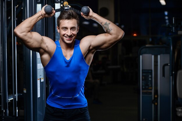 Séance d'entraînement de beau modèle jeune homme dans la salle de gym