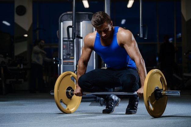 Séance d'entraînement de beau modèle jeune homme dans la salle de gym