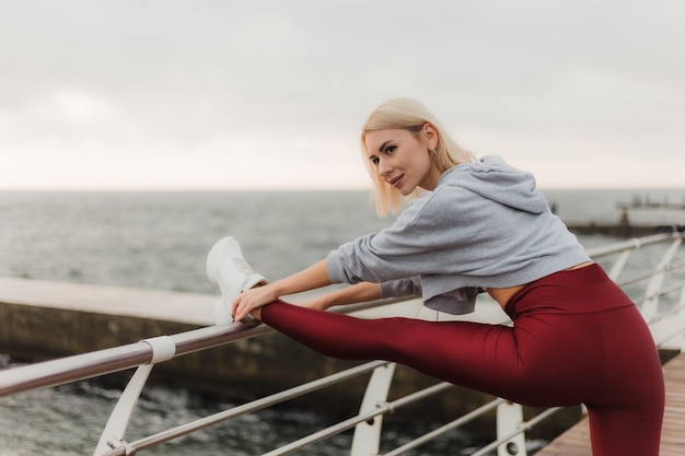 Séance d'entraînement du matin Concept de mode de vie sain Jeune femme séduisante en tenue de sport fait des étirements