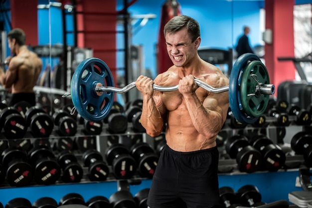 Séance d'entraînement de gars athlétique très puissant dans la salle de gym