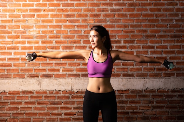 Séance d'entraînement de jolie fille sportive dans la salle de gym