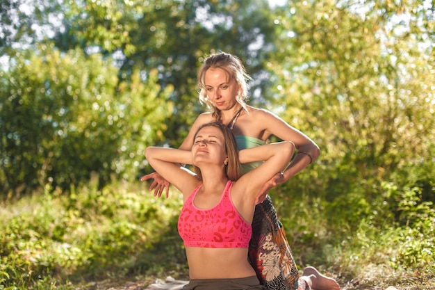 Séance de massage. L'entraîneur de massage donne à son client un massage rafraîchissant sur l'herbe.