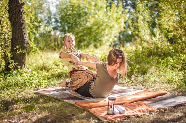 Séance de massage Un maître massothérapeute masse soigneusement une fille dans le calme à l'extérieur