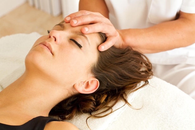 Séance de massages relaxants à une femme dans son visage et sa tête