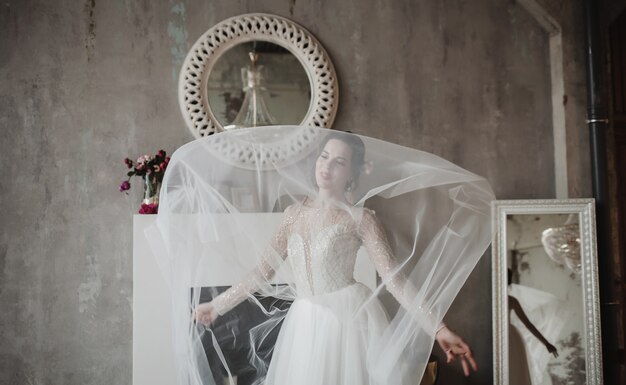 Séance de mode - belle mariée en magnifique robe de mariée posant en loft