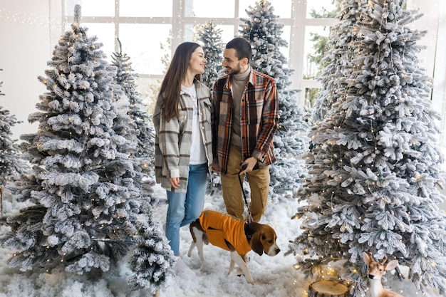 Séance photo dans le studio d'un jeune couple Couple avec leur chien Un gars avec une fille célèbre l'histoire d'amour de Noël Nouvel An