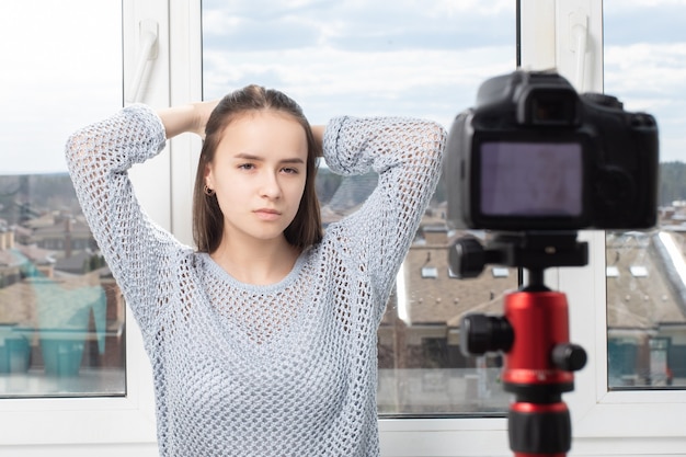 Séance photo à la maison. Fille posant devant la caméra, prend des photos