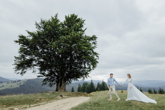 Séance photo de la mariée et du marié dans les montagnes. Photo de mariage de style Boho.