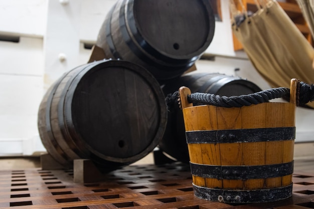 Photo seau en bois près de barils de poudre dans la salle de stockage du navire de combat