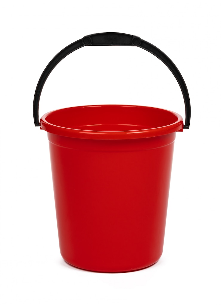 Photo seau domestique en plastique rouge vide sur une surface blanche