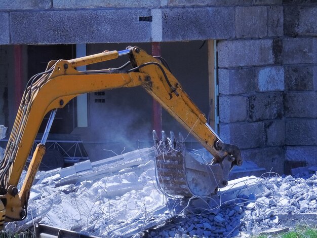 Photo un seau d'une excavatrice hydraulique recueille les décombres après une démolition