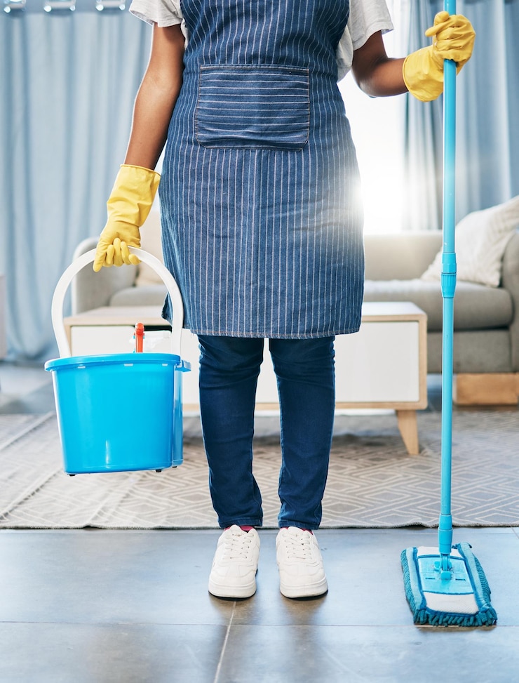 Photo seau de nettoyage et vadrouille avec les pieds des femmes dans le salon pour l'hygiène sanitaire et la désinfection ménage et entretien avec une fille avec un récipient pour les bactéries chimiques ou la routine de désinfection
