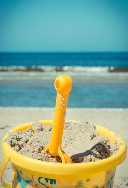 Photo un seau en plastique avec une échafaudage utilisé pour se détendre et jouer sur le sable à la plage les vacances d'été et le développement de l'enfant